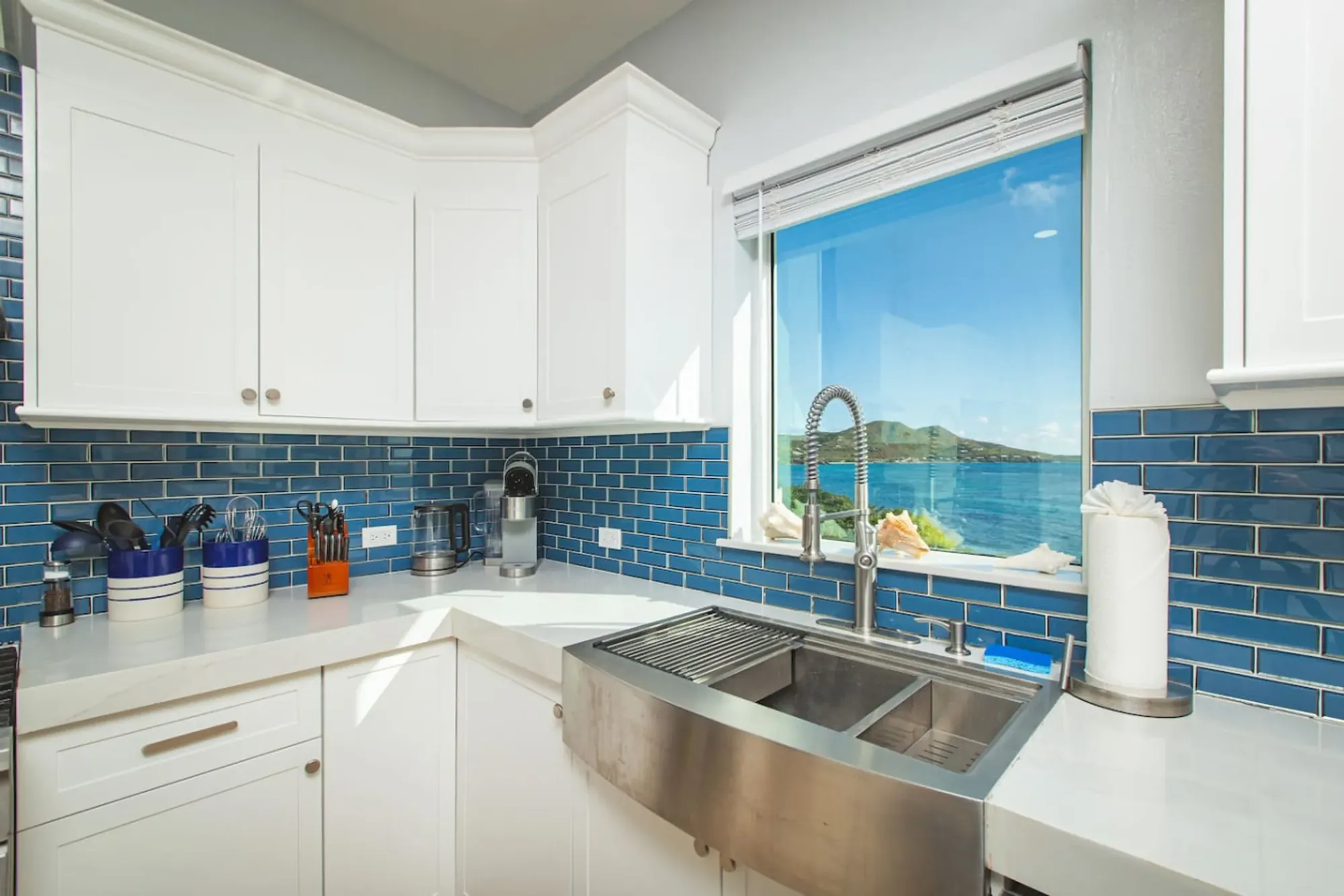 Farmhouse sink beneath a window over the water