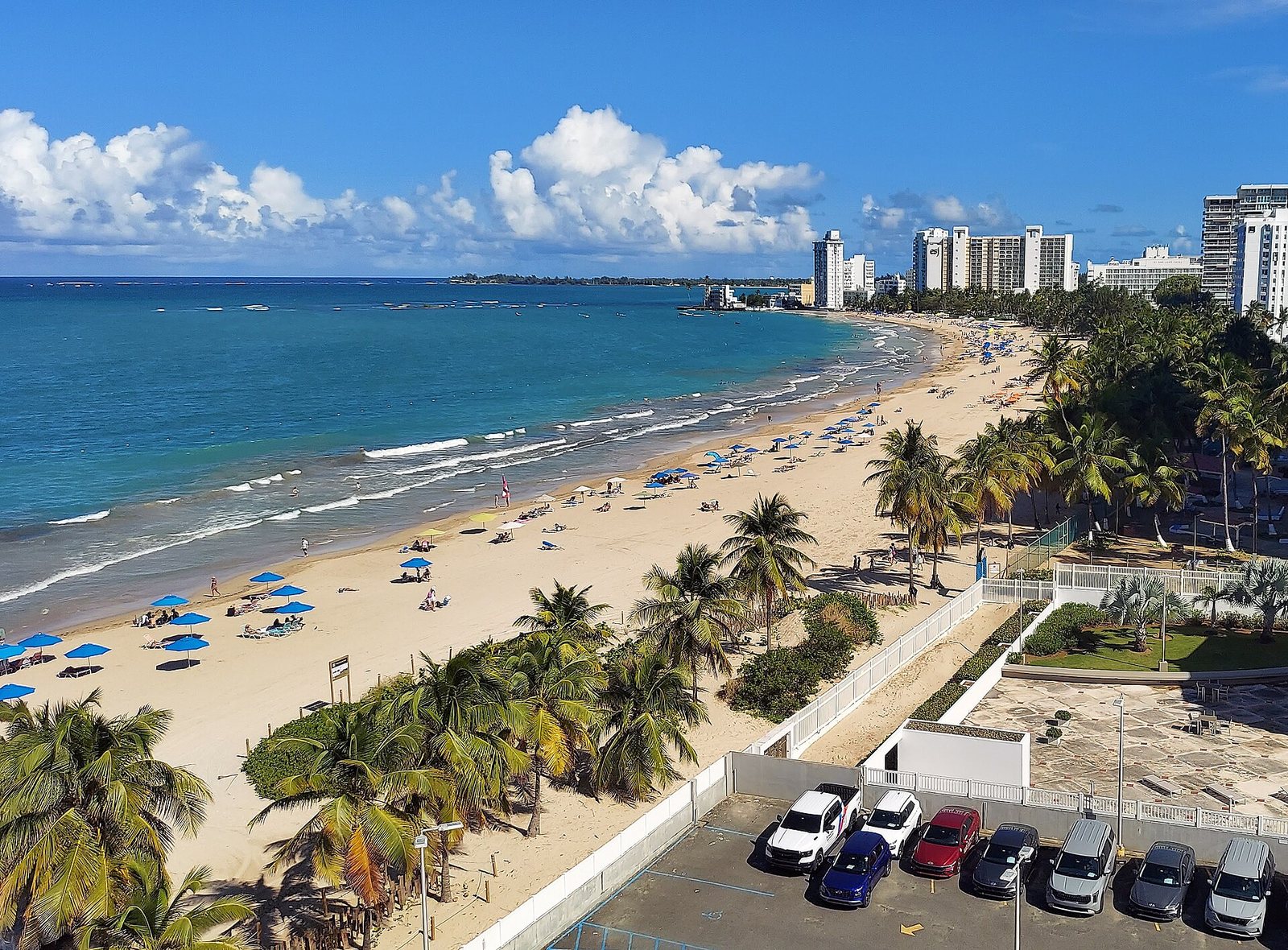 Isla Verde beach in Carolina, Puerto Rico, lined with palms and hotel towers