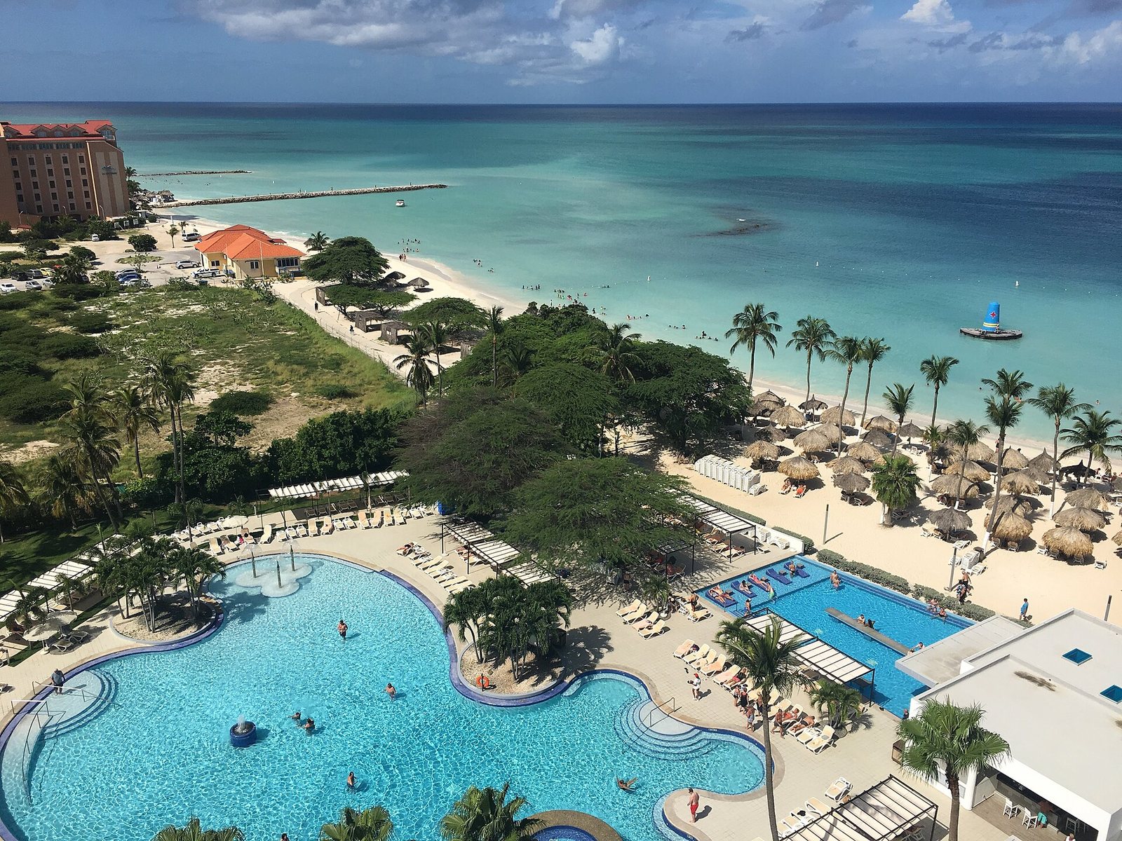 A resort pool beside Palm Beach on Aruba, seen from above
