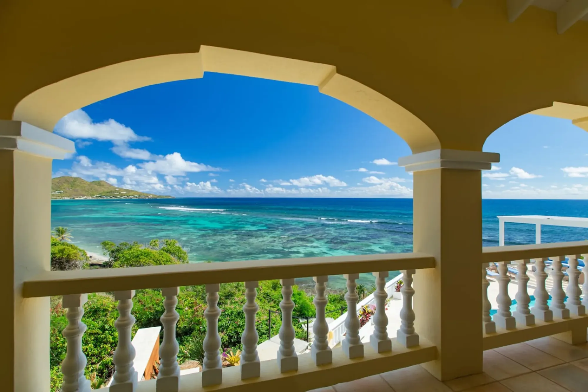 Turquoise bay framed by the villa's arched veranda